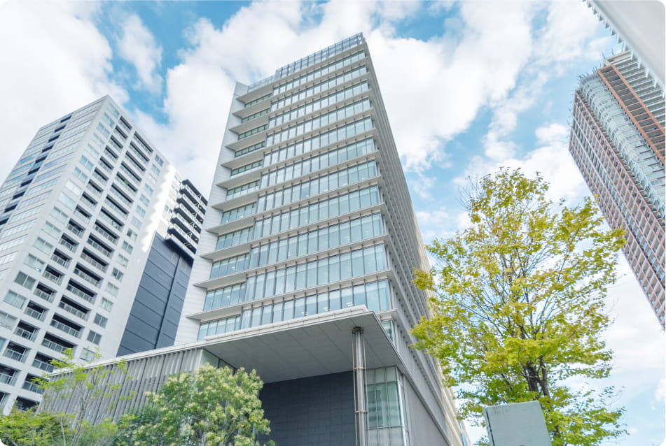 ガラス張りの高層ビルが青空の下にそびえ立っている