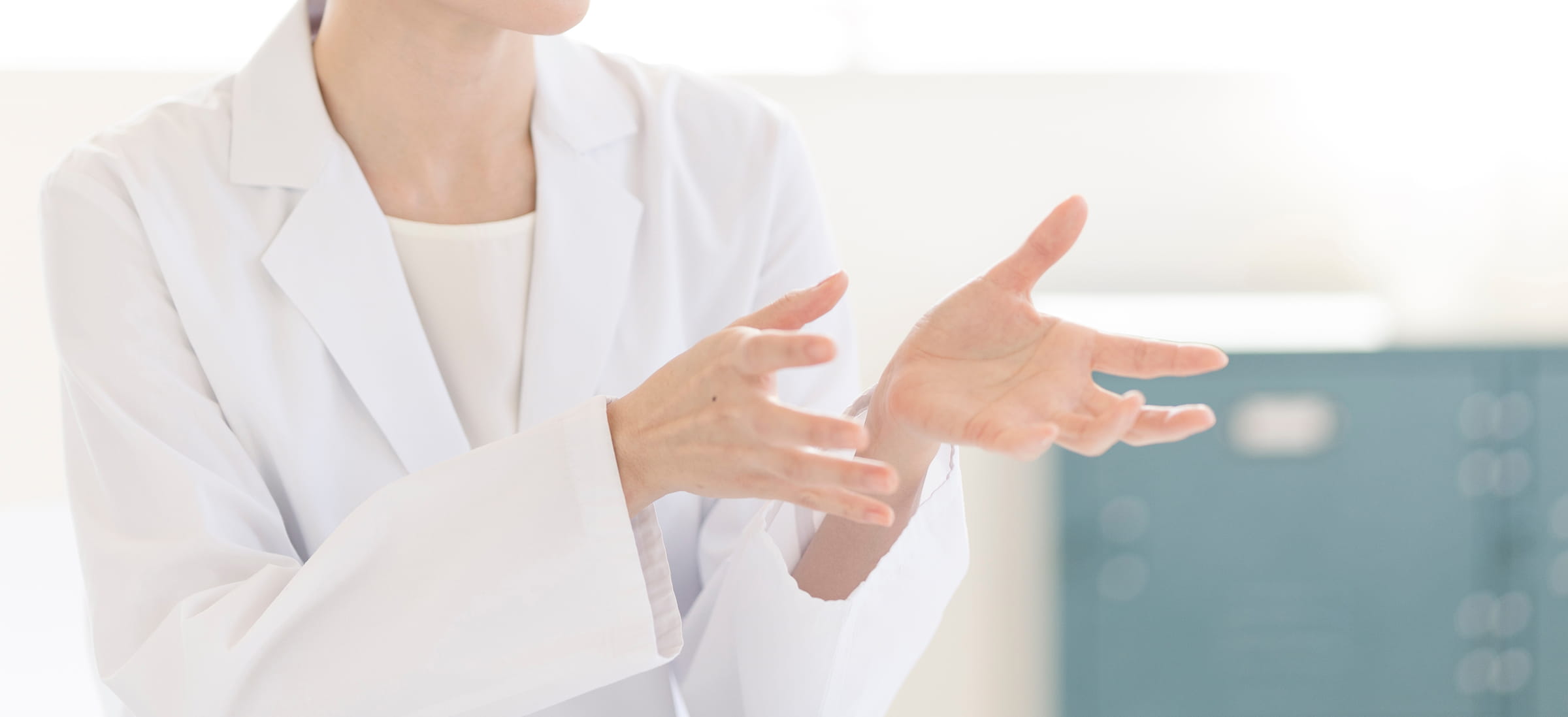 白衣を着た研究員が業務について説明する様子。