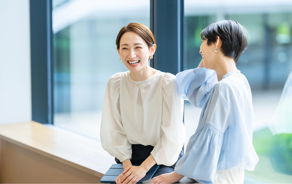 社員同士が笑顔で会話する様子。