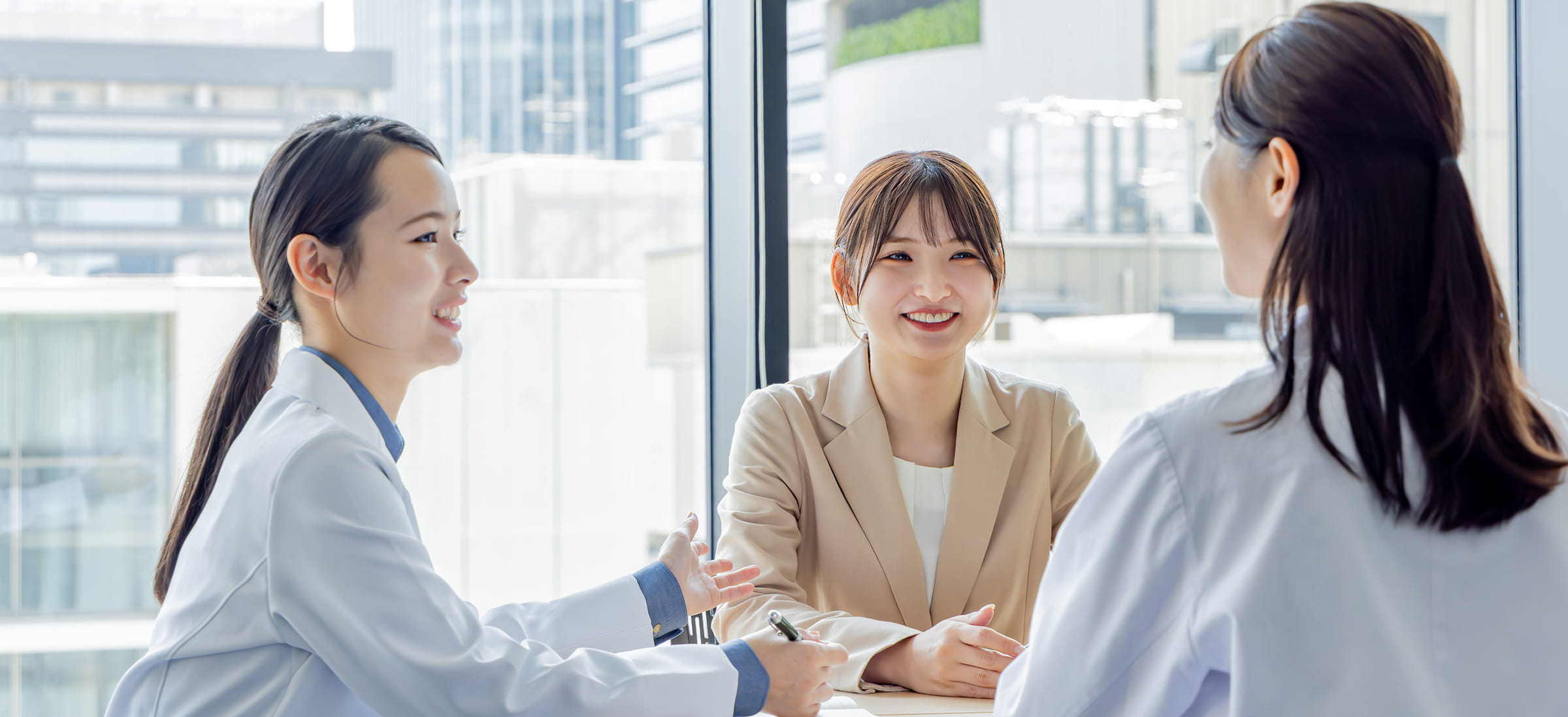 DNAチップ研究所の社員が明るい雰囲気でインタビューに応じる様子。